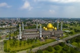 An outdoor view of a mosque surrounded by greenery.