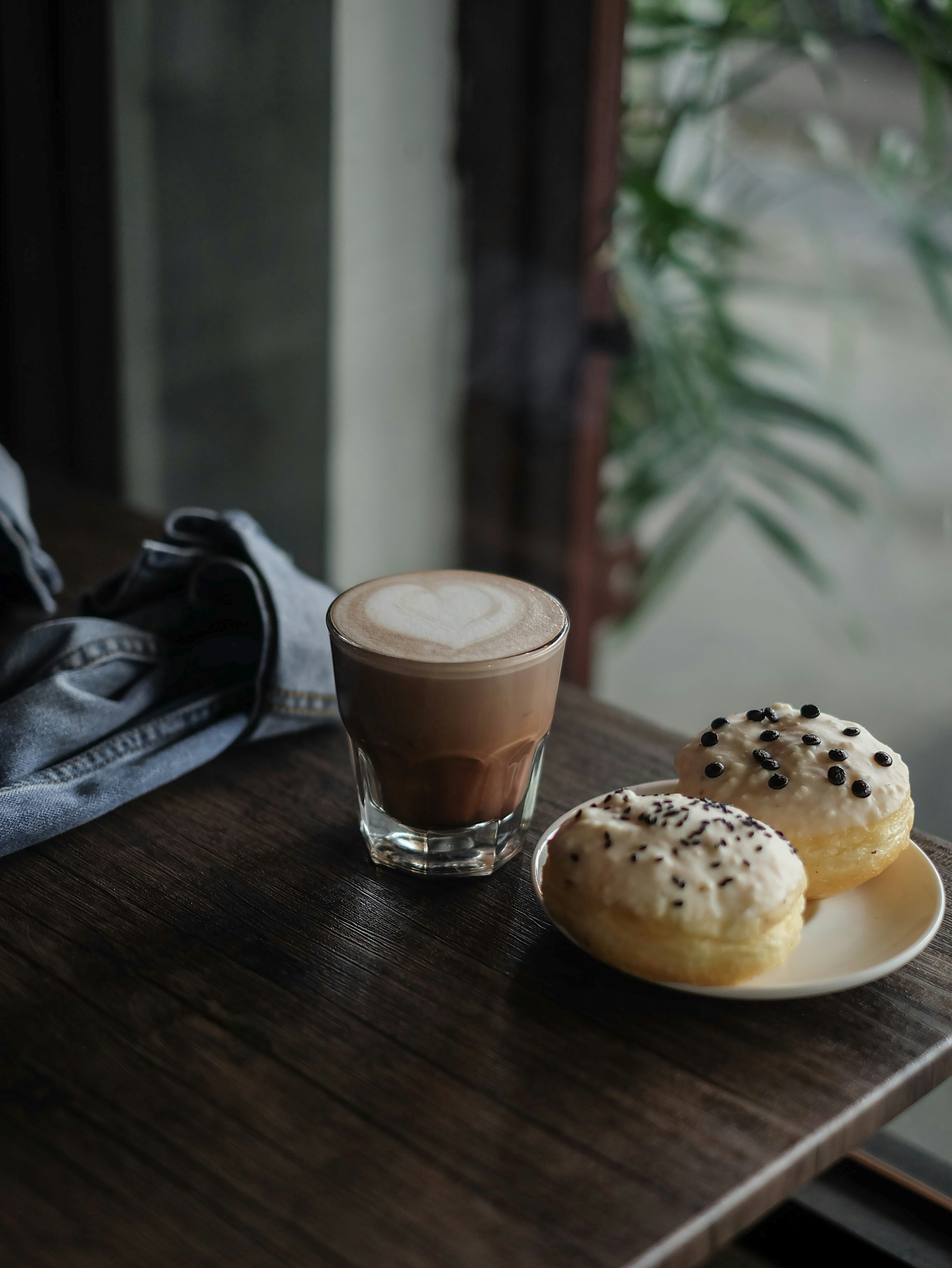 a cup of coffee next to a plate of donuts