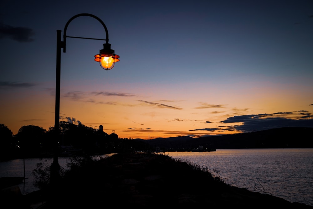 a street light with a sunset in the background