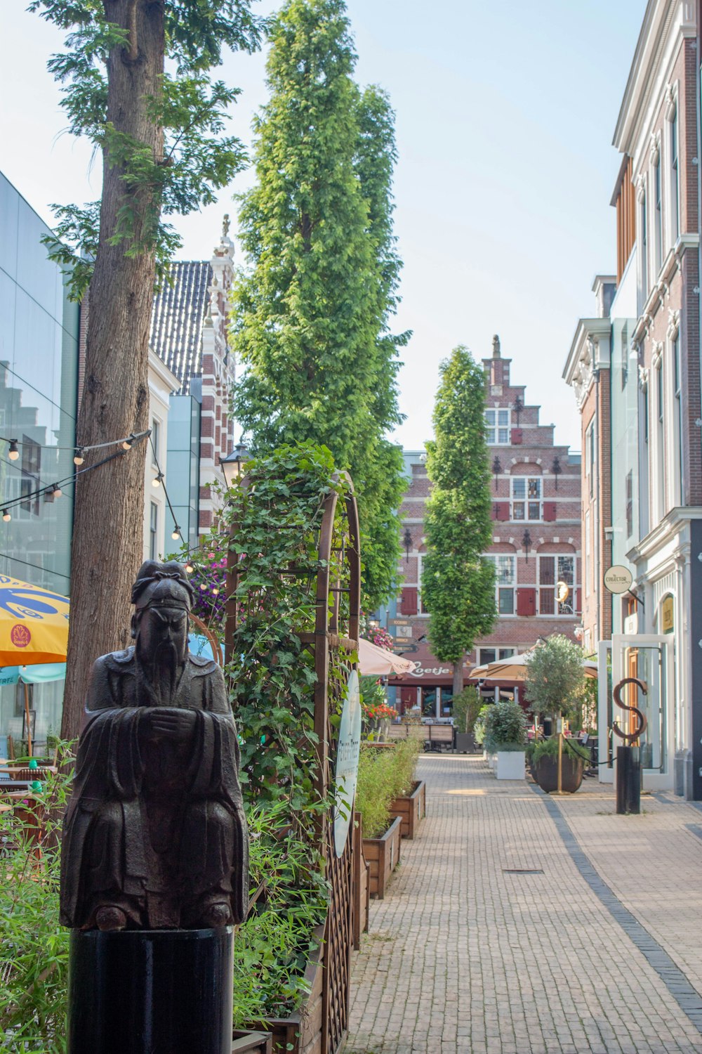 a statue of a person in a robe on a sidewalk