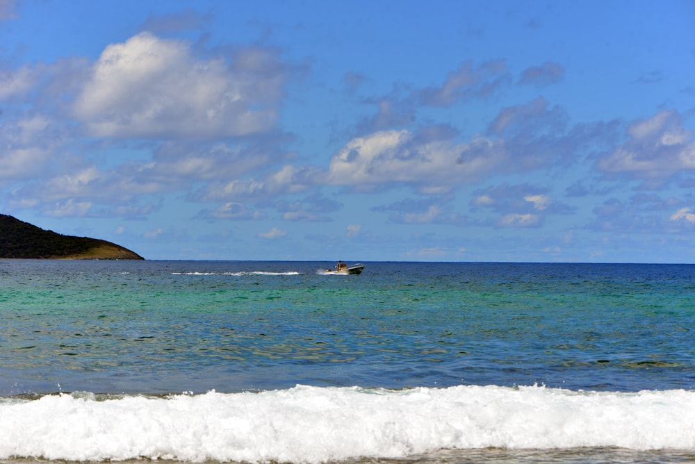 a body of water with a boat in it and a land in the back