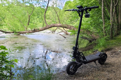 A sleek electric scooter parked in a serene outdoor setting.