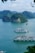 Cruise ships are sailing on tranquil blue-green waters, surrounded by lush green limestone islands. The expansive scene is framed by a bright, cloudy sky and leafy branches in the foreground, creating a peaceful and picturesque maritime landscape.