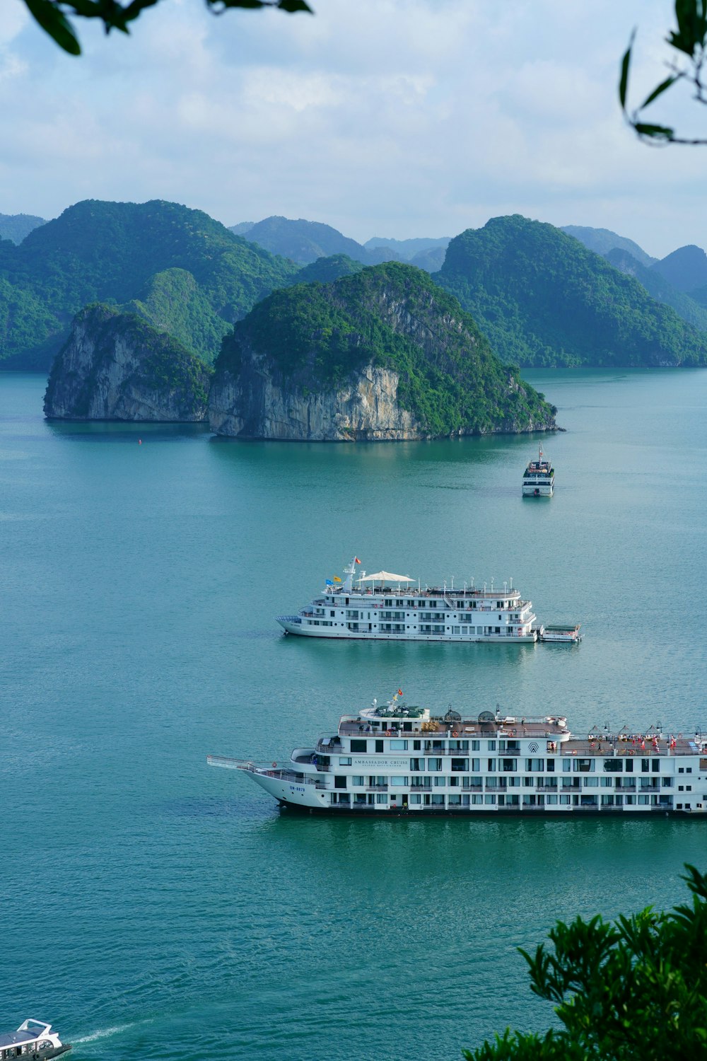 a couple of boats on a body of water with islands in the background