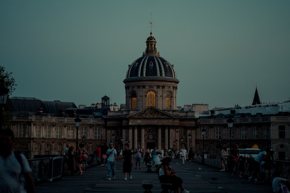 a large building with a dome and many people walking around