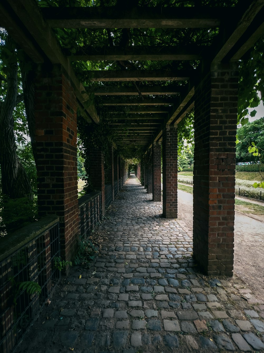 a stone walkway with brick archways