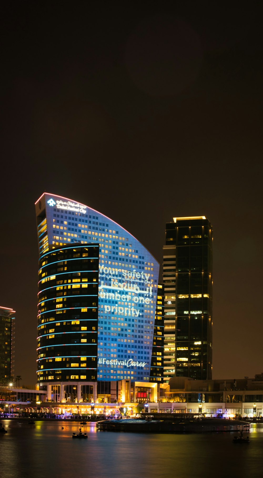 a couple of tall buildings with lights on at night