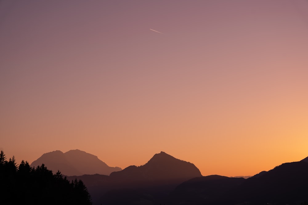 un coucher de soleil sur une chaîne de montagnes