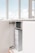 An open kitchen cabinet reveals a water filtration or purification system installed inside. The space is well-lit and minimalistic with a modern faucet visible on the counter above.