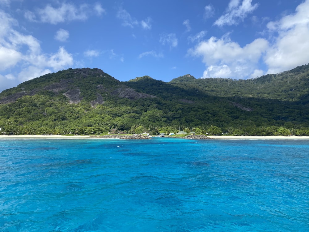 a body of water with a hill in the background