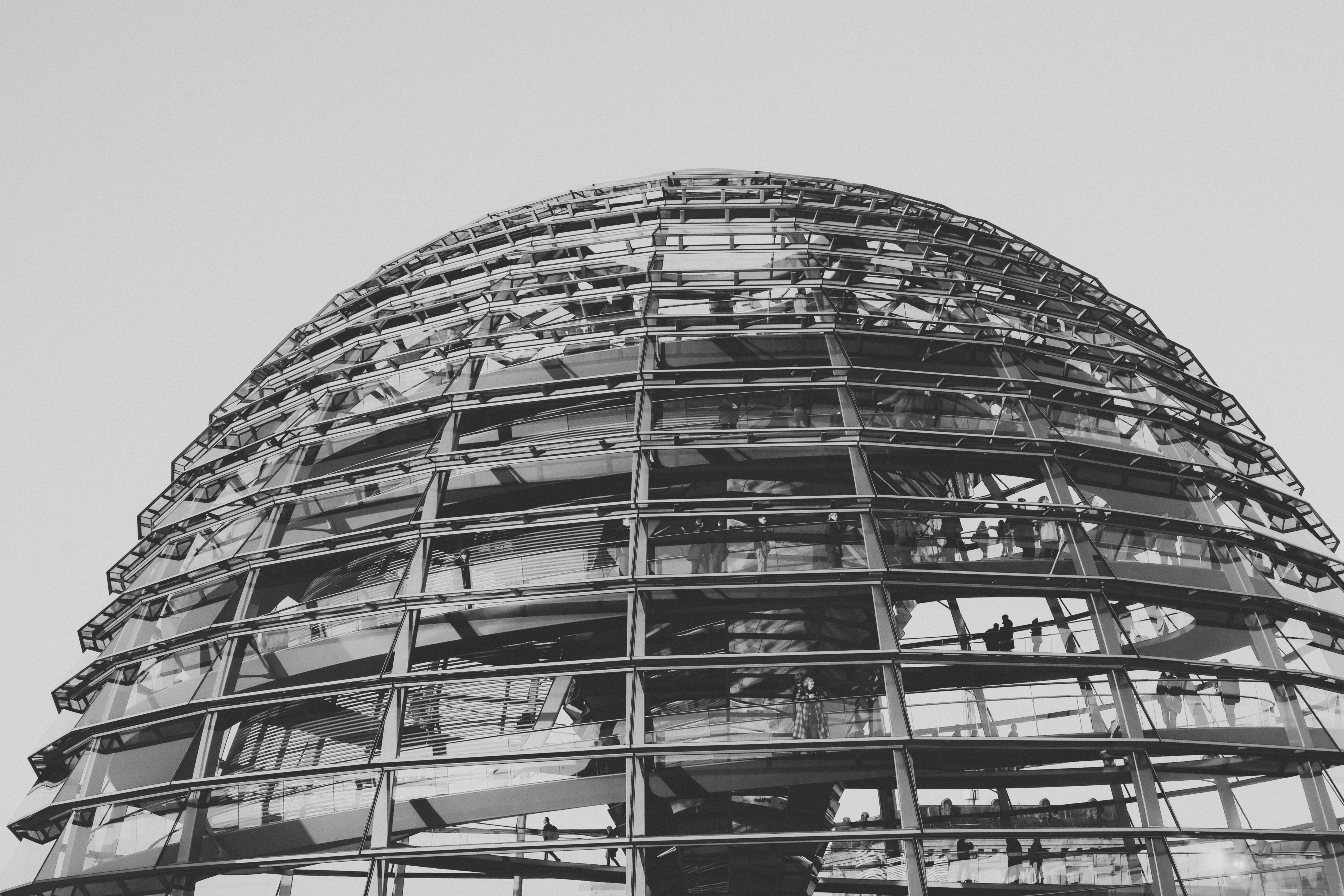 a tall building with many windows with Reichstag dome in the background