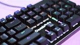 A close-up view of a mechanical keyboard with RGB backlighting, showcasing various keys like F11, DEL, and END prominently. The keyboard has a black finish, and the lights create a colorful effect across the keys, enhancing its visual appeal.