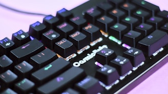 A close-up view of a mechanical keyboard with RGB backlighting, showcasing various keys like F11, DEL, and END prominently. The keyboard has a black finish, and the lights create a colorful effect across the keys, enhancing its visual appeal.