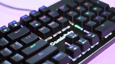 A close-up view of a mechanical keyboard with RGB backlighting, showcasing various keys like F11, DEL, and END prominently. The keyboard has a black finish, and the lights create a colorful effect across the keys, enhancing its visual appeal.