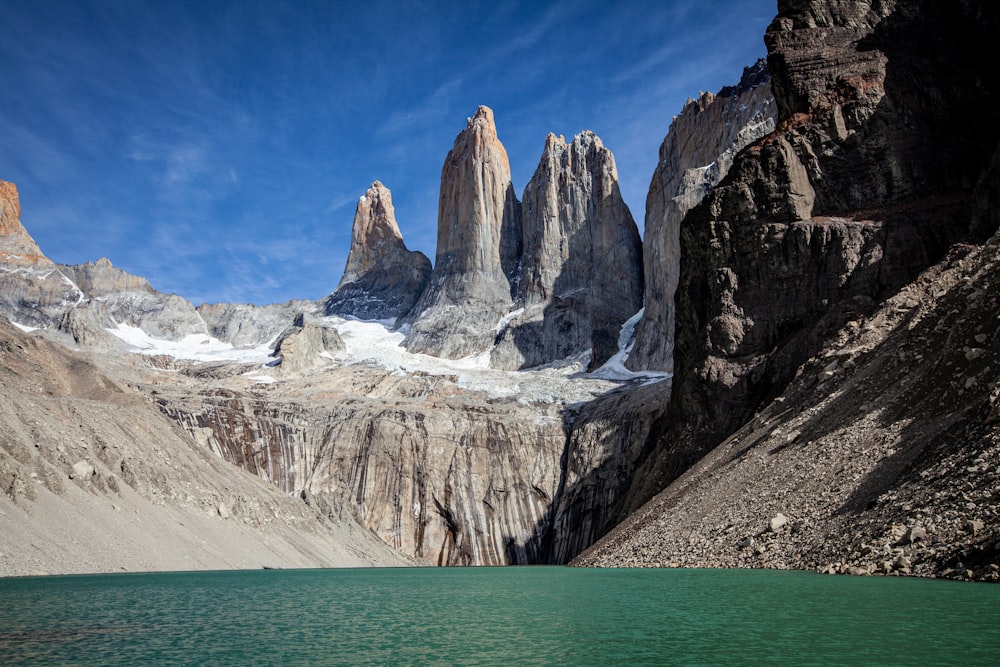 a body of water with rocky mountains in the background with Torres del Paine National Park in the background