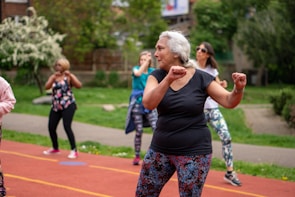 A group of senior learners participating enthusiastically in a sports day relay race.