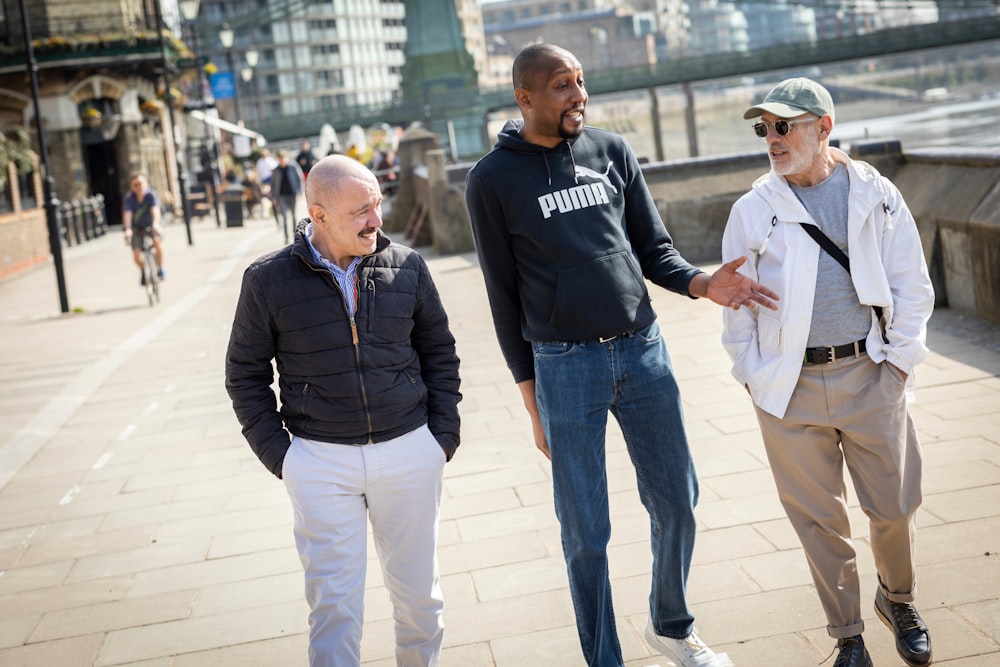 a group of men walking on a sidewalk