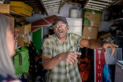 Fred and Leslie sharing a laugh over a strange hobby in a cluttered garage.