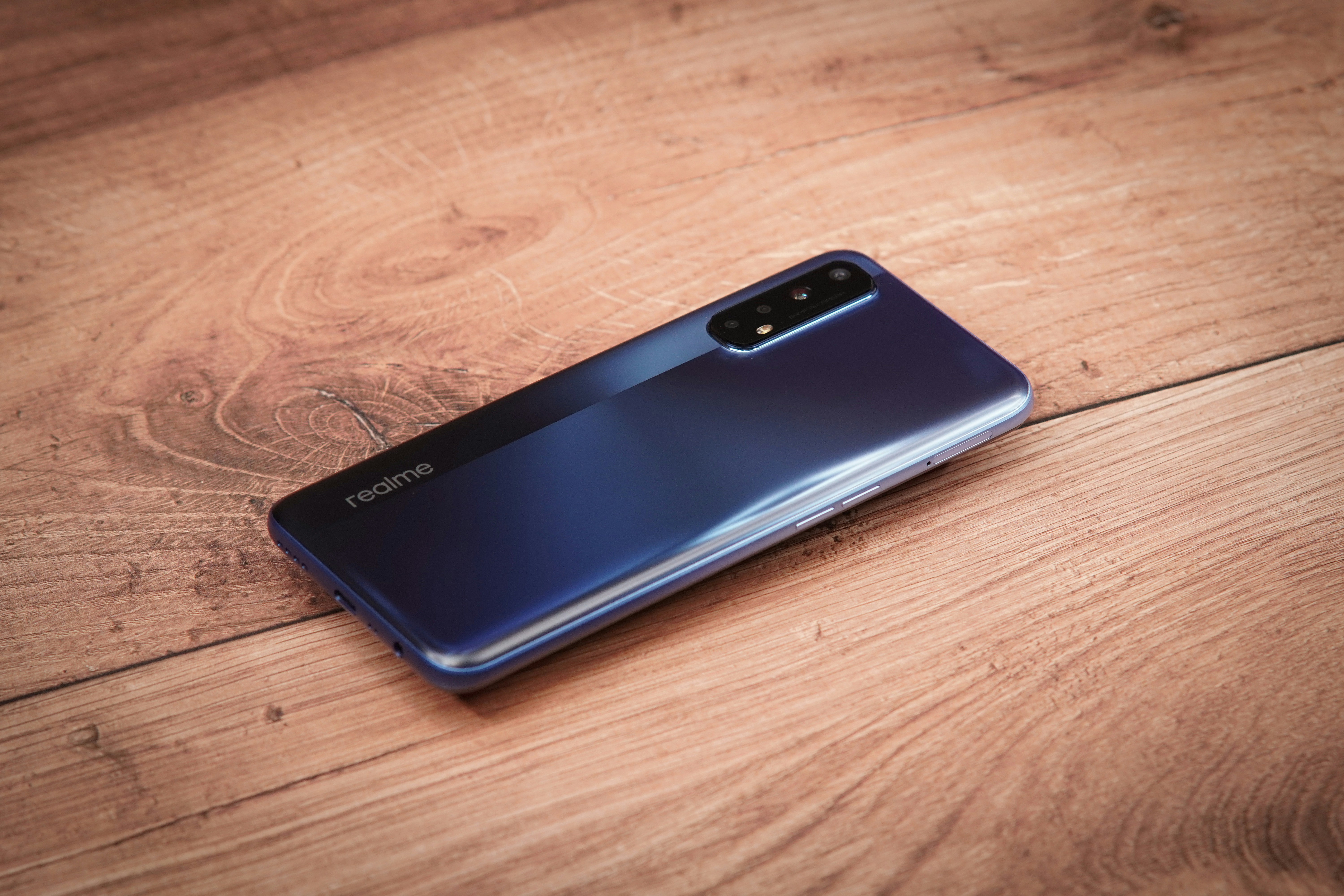 Blue realme phone on a wooden table