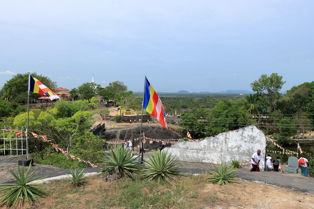 a group of people standing around a stone wall with flags