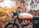 Photo of Amit Raj smiling beside his restored Royal Enfield in an urban Indian street