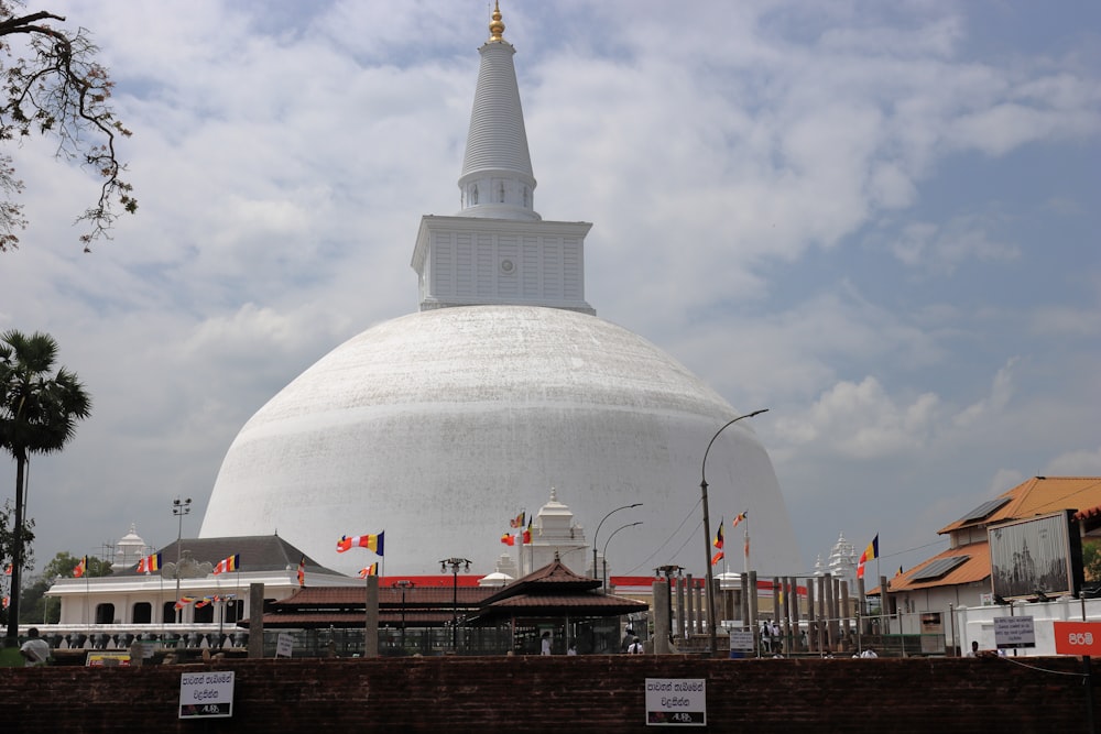 ein großes weißes Gebäude mit einer Kuppel mit Anuradhapura im Hintergrund