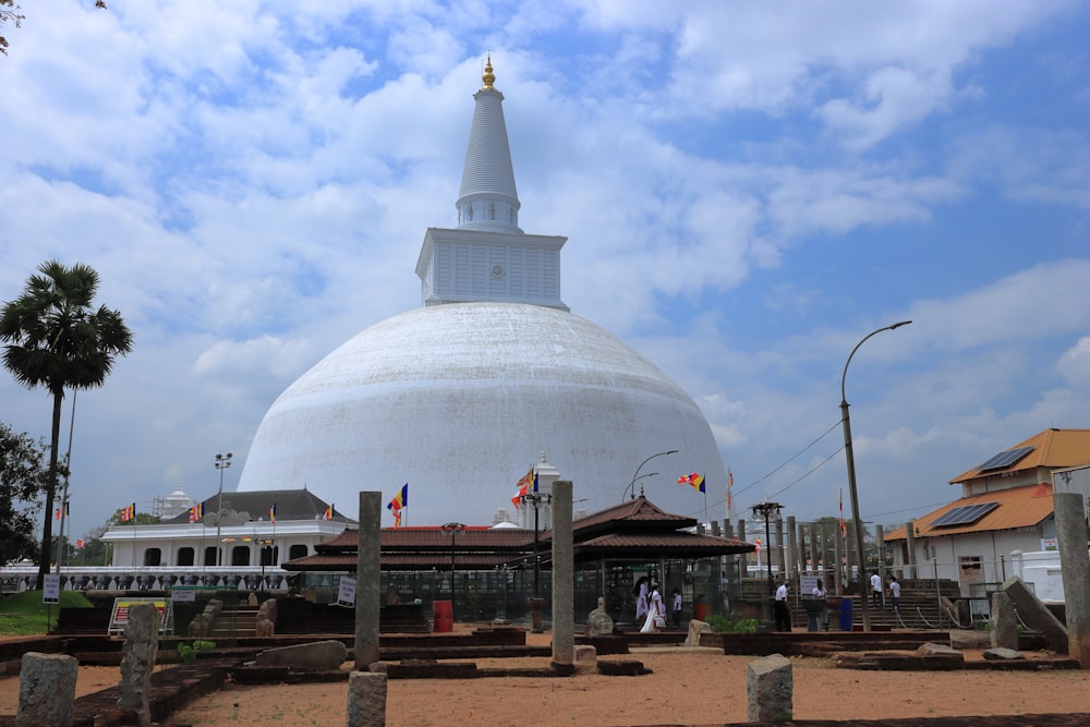a large white building with a dome with Anuradhapura in the background