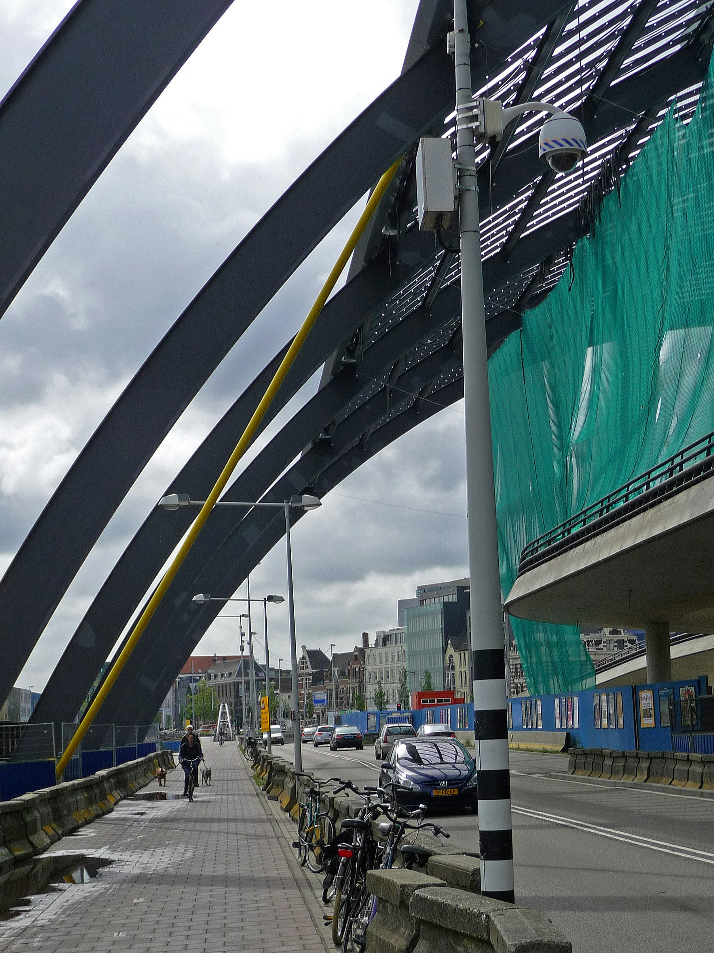 Photo Amsterdam city, free download: man is biking under the steel columns of the roof of the new busstation, along the IJ river; photo, Fons Heijnsbroek, 2010 - street photography in high resolution of The Netherlands, free image CC0. . Foto van Amsterdam, gratis downloaden: bouw van het busstation achter het C.S. - aan het IJ, de Ruiterkade; foto Fons Heijnsbroek, 2010, rechtenvrij - straatfotografie uit Nederland in hoge resolutie CC0.