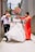 A joyful wedding scene with guests dancing and a harmonica player in the background.