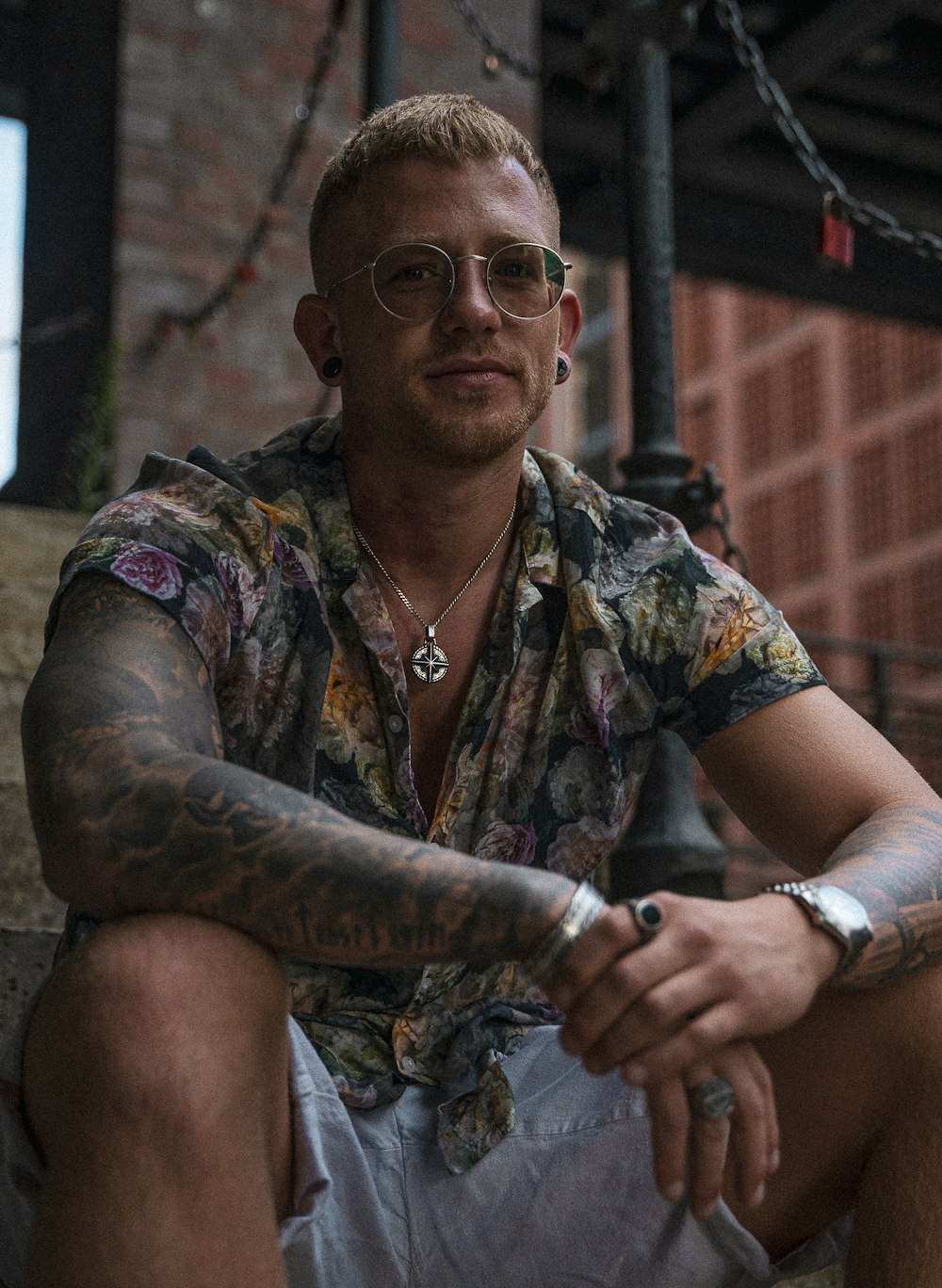 a man with tattoos and a necklace