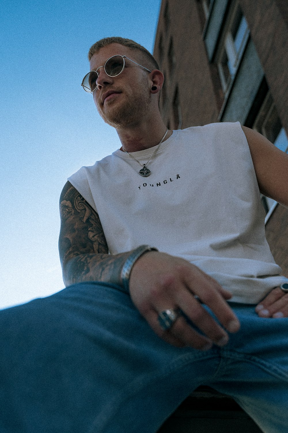 a man with tattoos and glasses