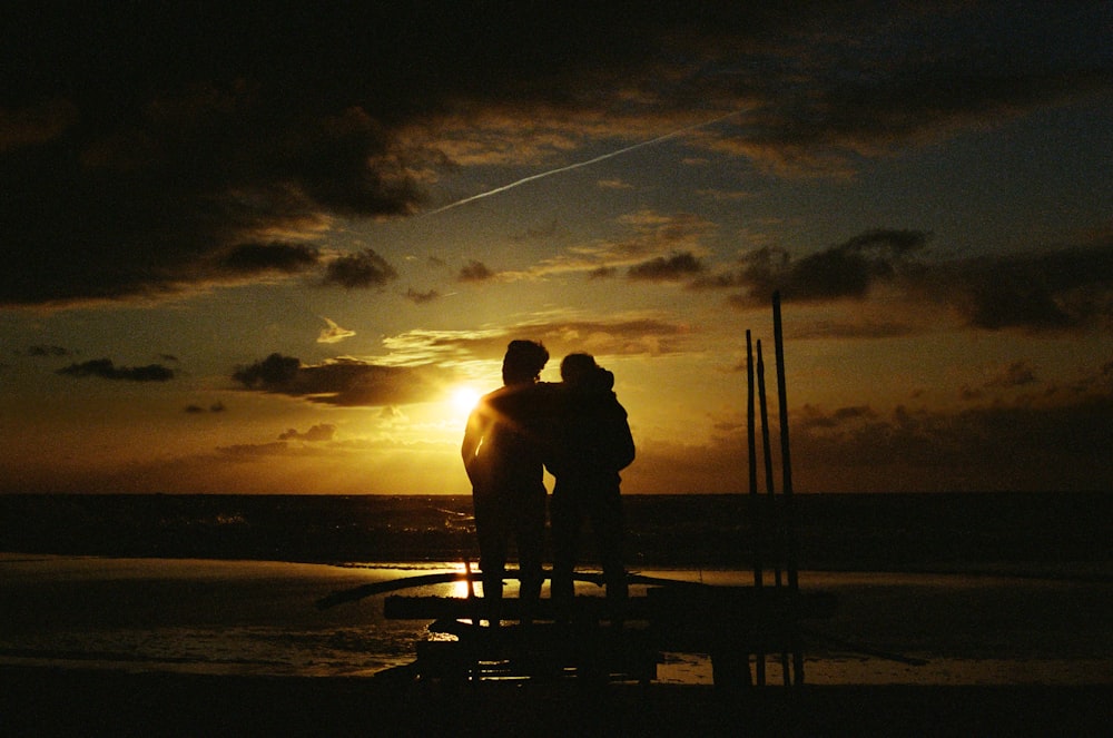 a couple of people stand on a beach