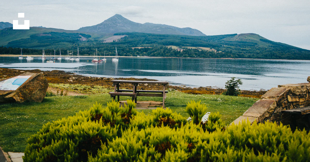 A bench sits by a lake photo – Free Glen rosa Image on Unsplash