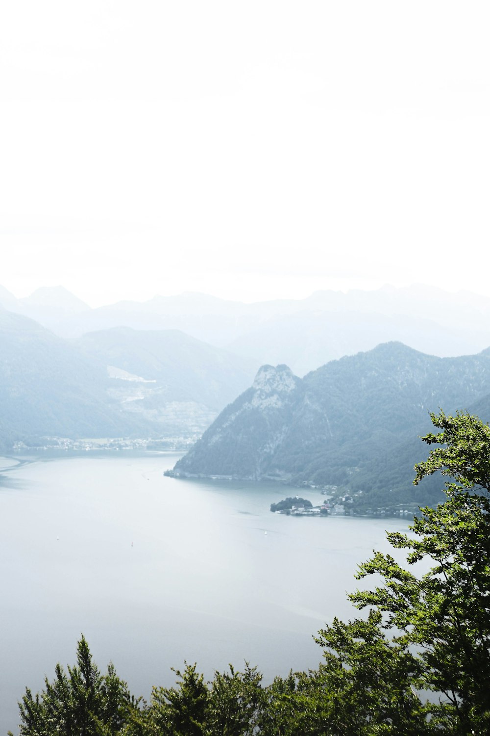 a body of water with trees and mountains in the background