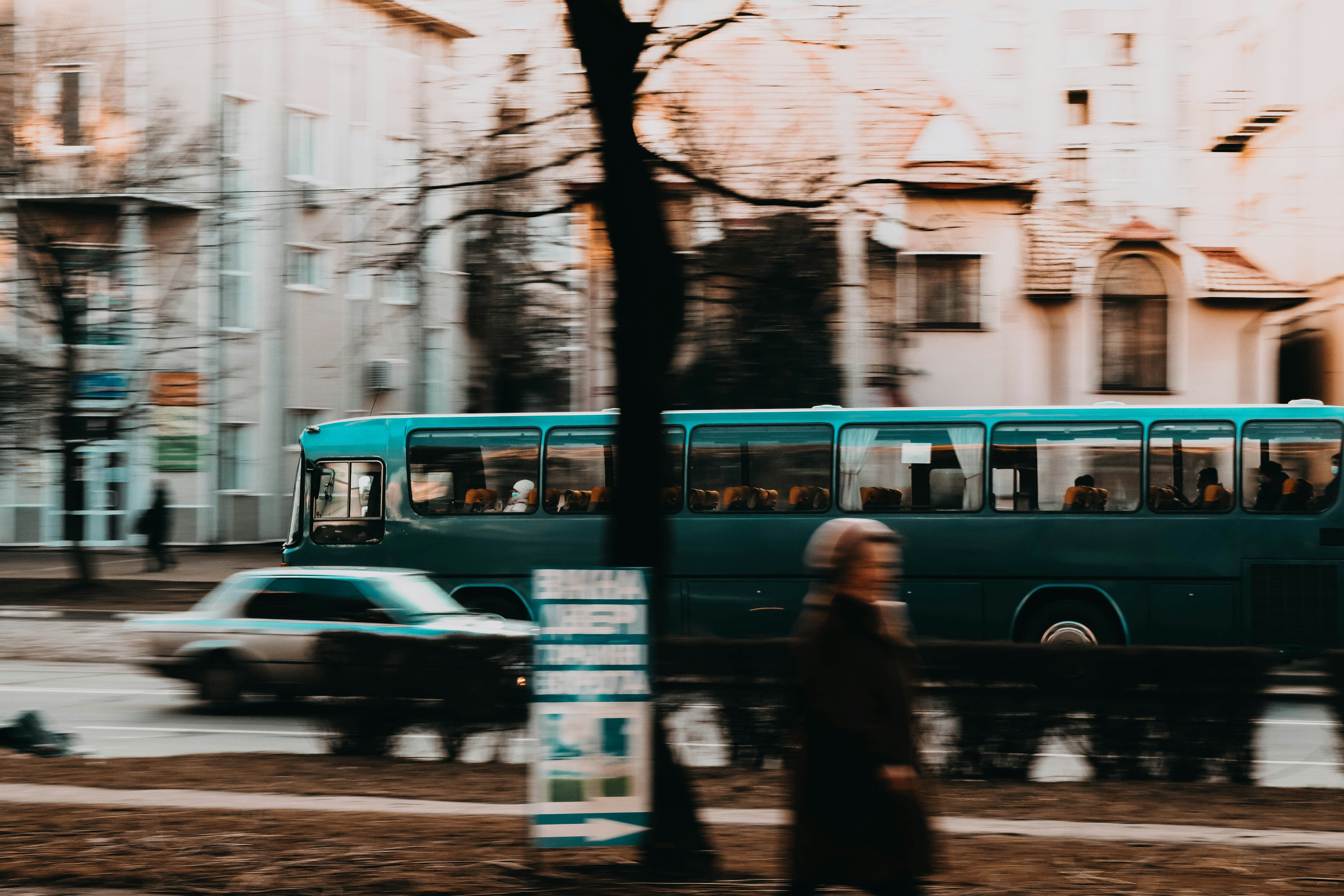 a person walking on the sidewalk next to a bus