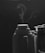 A black and white image depicting two thermoses side by side with steam rising gently from the open lid of the one on the left. The background is dark, which emphasizes the wisps of steam.