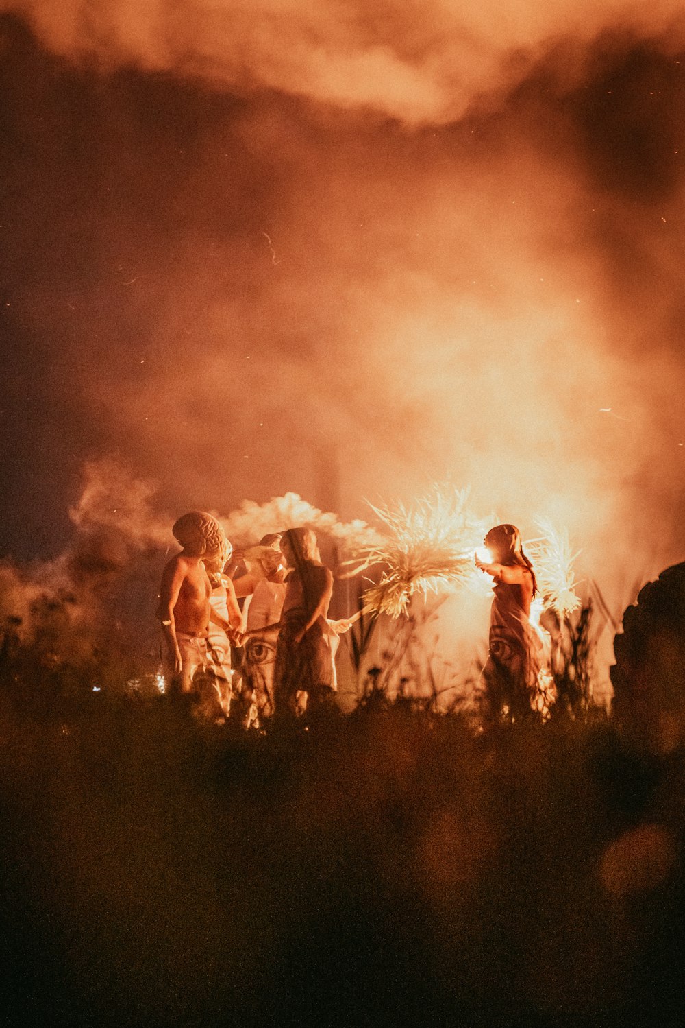 a group of people standing in front of a fire