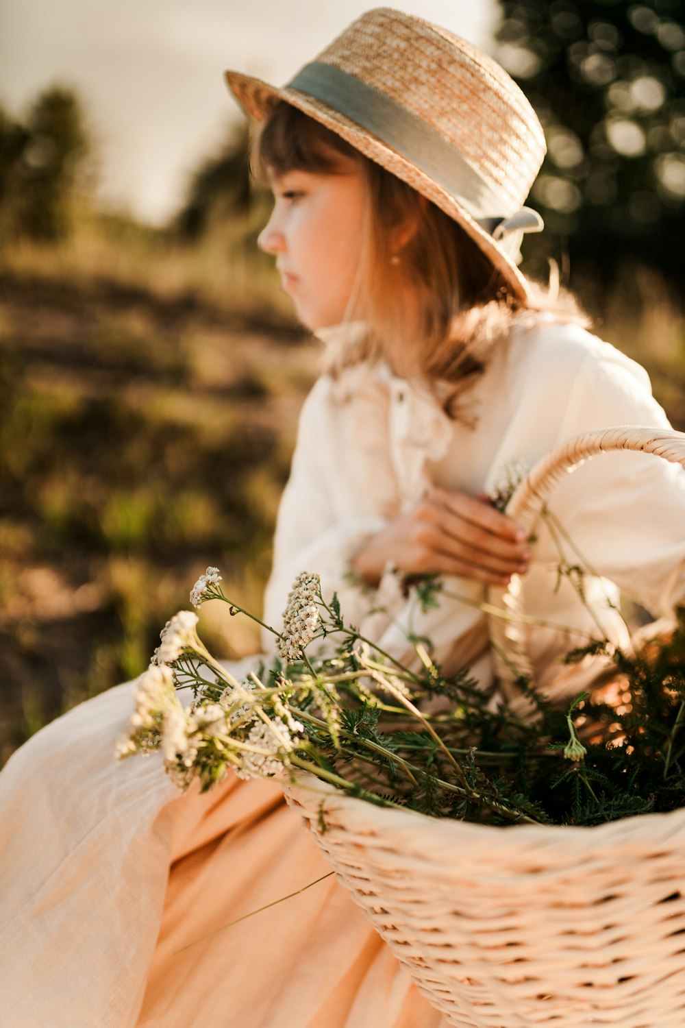 a woman in a hat holding flowers