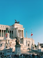 a large white building with columns and statues in front of it
