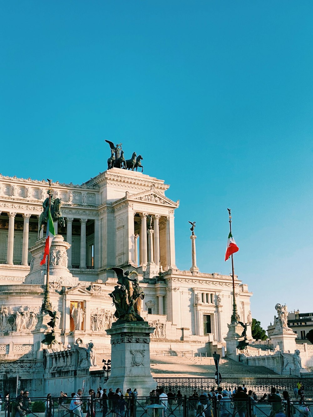 a large white building with columns and statues in front of it