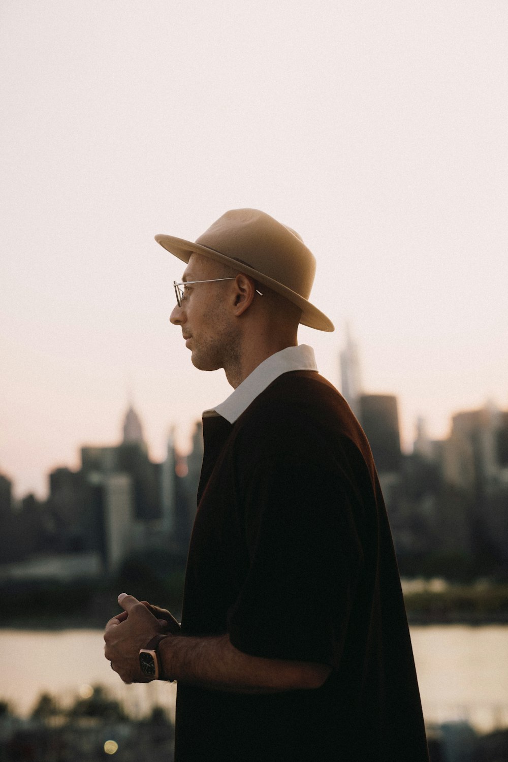 a man in a suit and hat looking at his phone