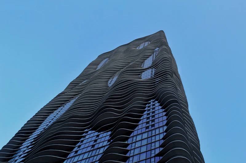 Looking up at Aqua Tower's rippling, wave-like balcony facade against a blue sky