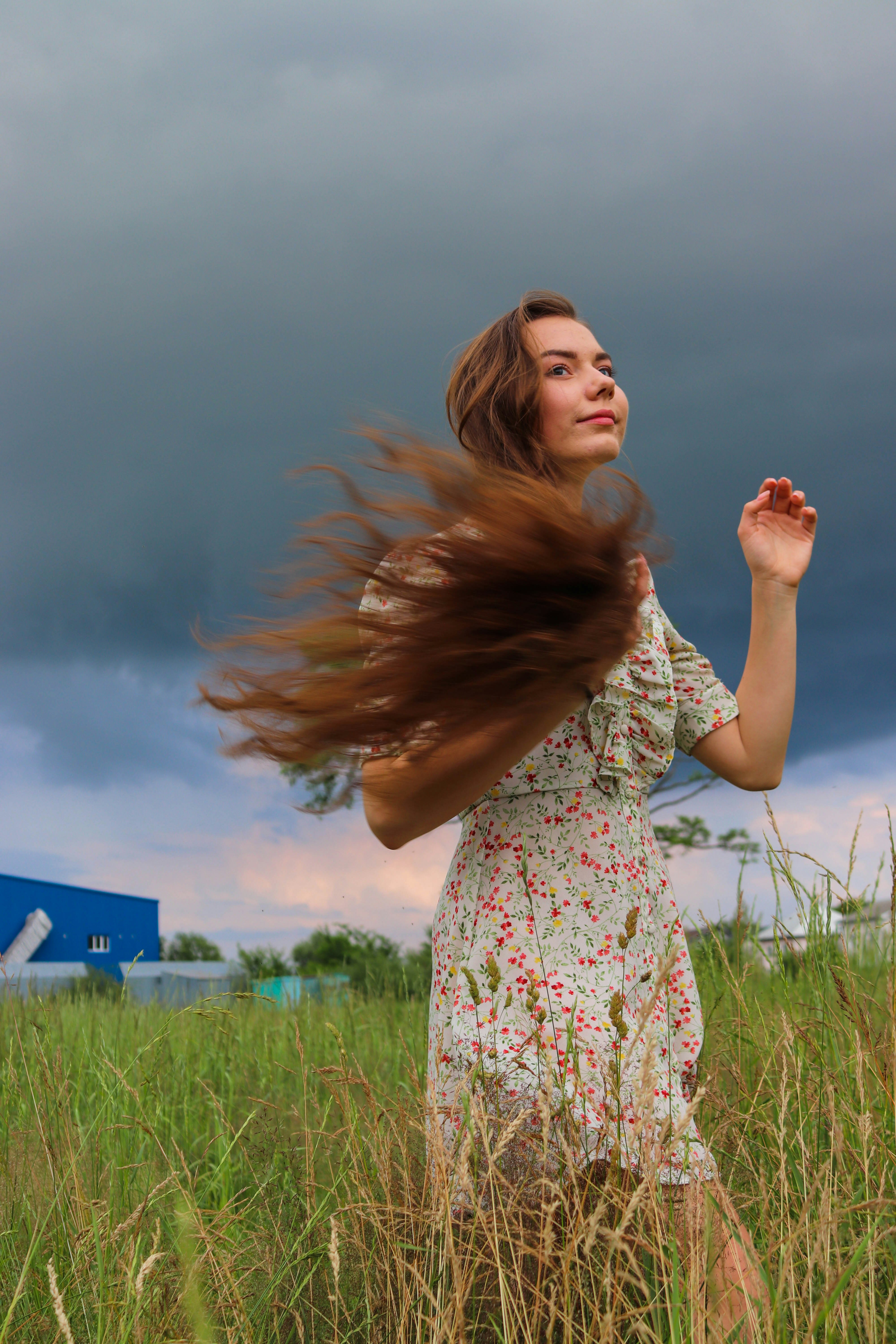 A woman with a thoughtful expression, looking at a stylized moon and cycle phases, representing internal emotional shifts and cyclical patterns.