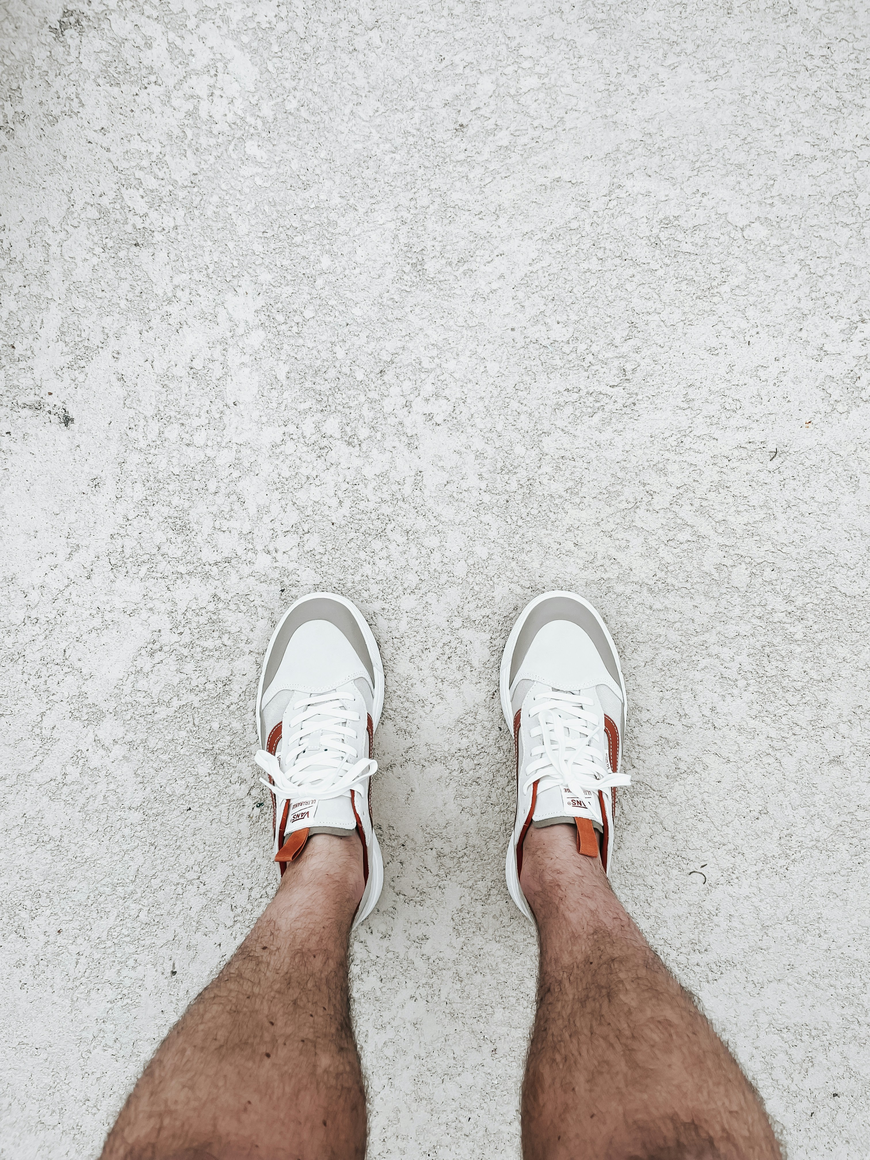a person's legs with white shoes on