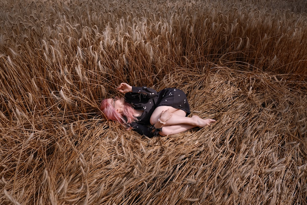 a person lying in a field of dry grass