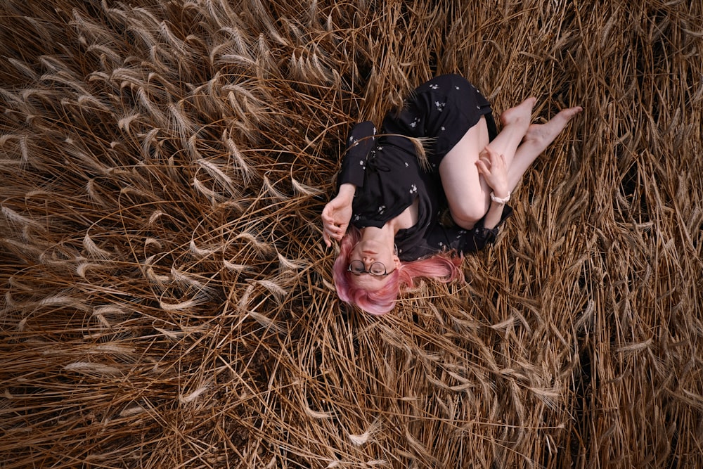 a person lying in a field of hay