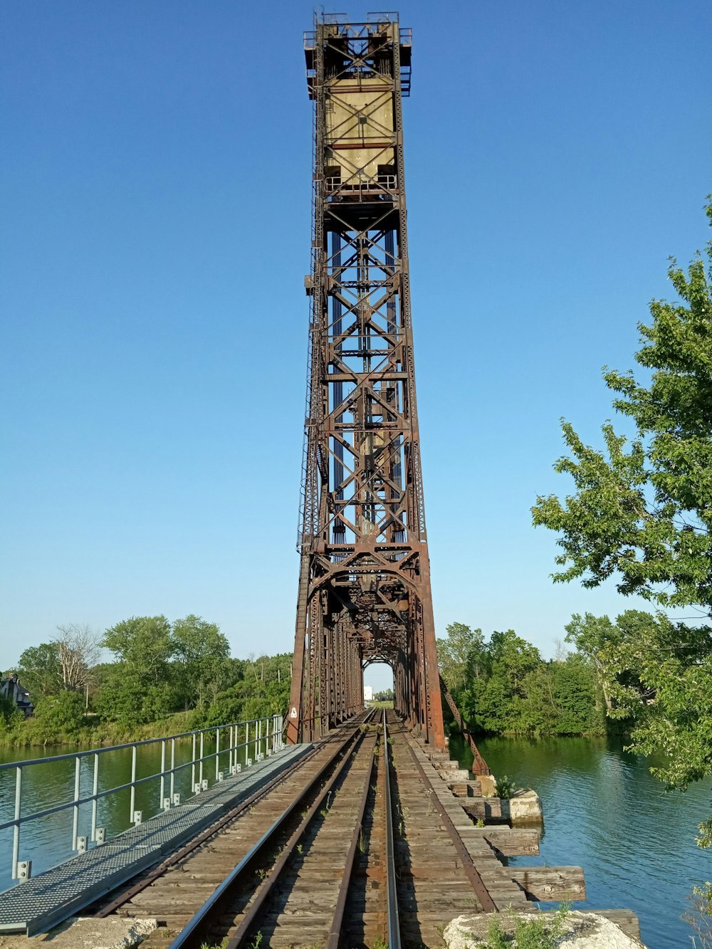 a large metal tower next to a body of water