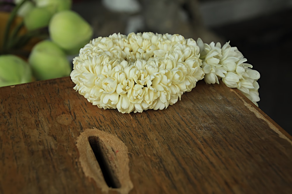 a bunch of white flowers on a wooden surface
