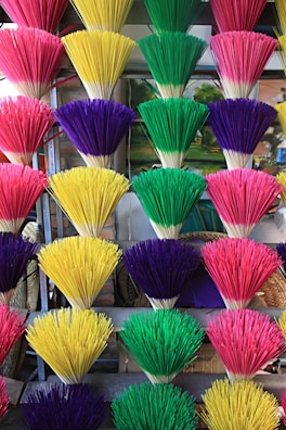 Colorful agarbatti sticks bundled together with saffron and gold packaging.