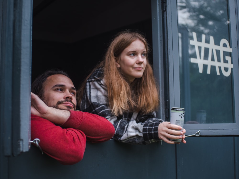 a man and woman sitting in a window